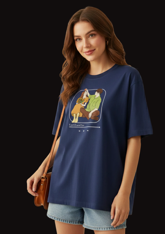 Woman wearing a navy blue t-shirt with a graphic design, holding a brown leather bag.