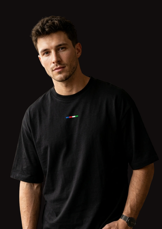 Man wearing a black t-shirt with a small colorful logo on a white background