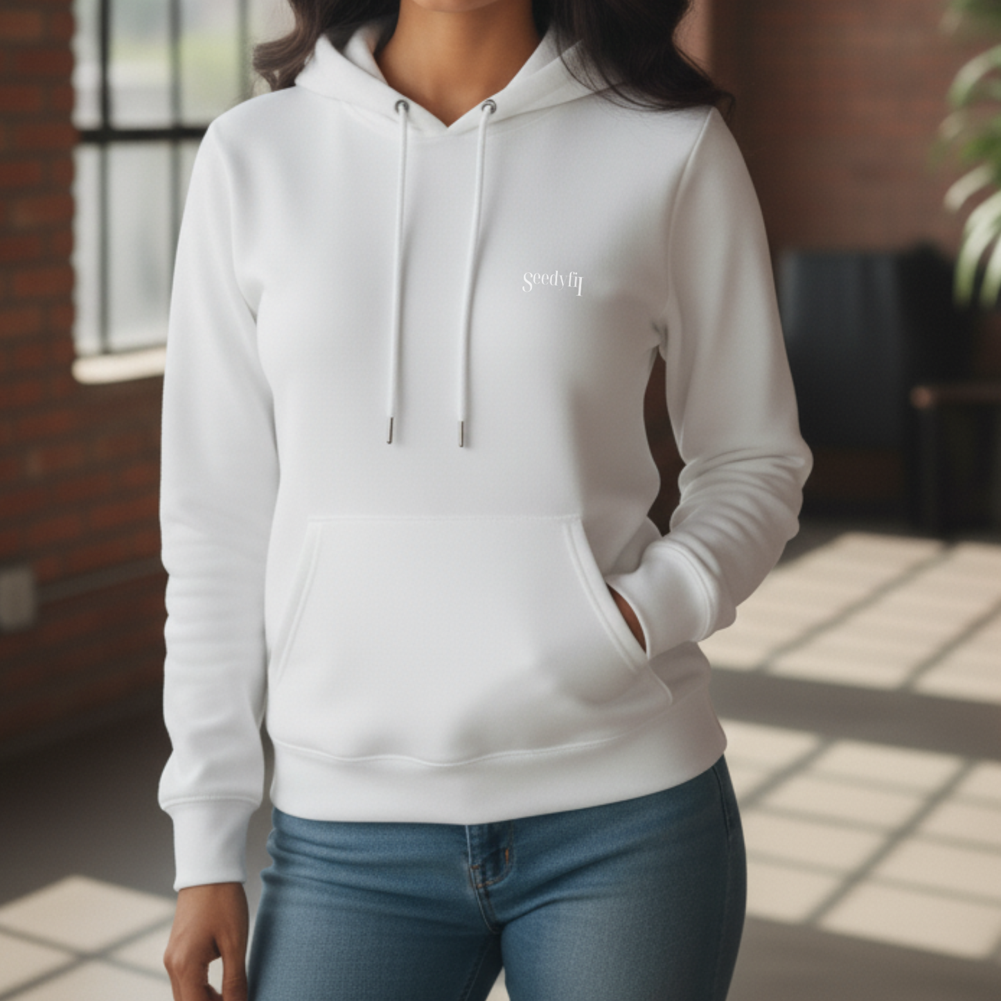 Person wearing a white hoodie with a logo, standing indoors.